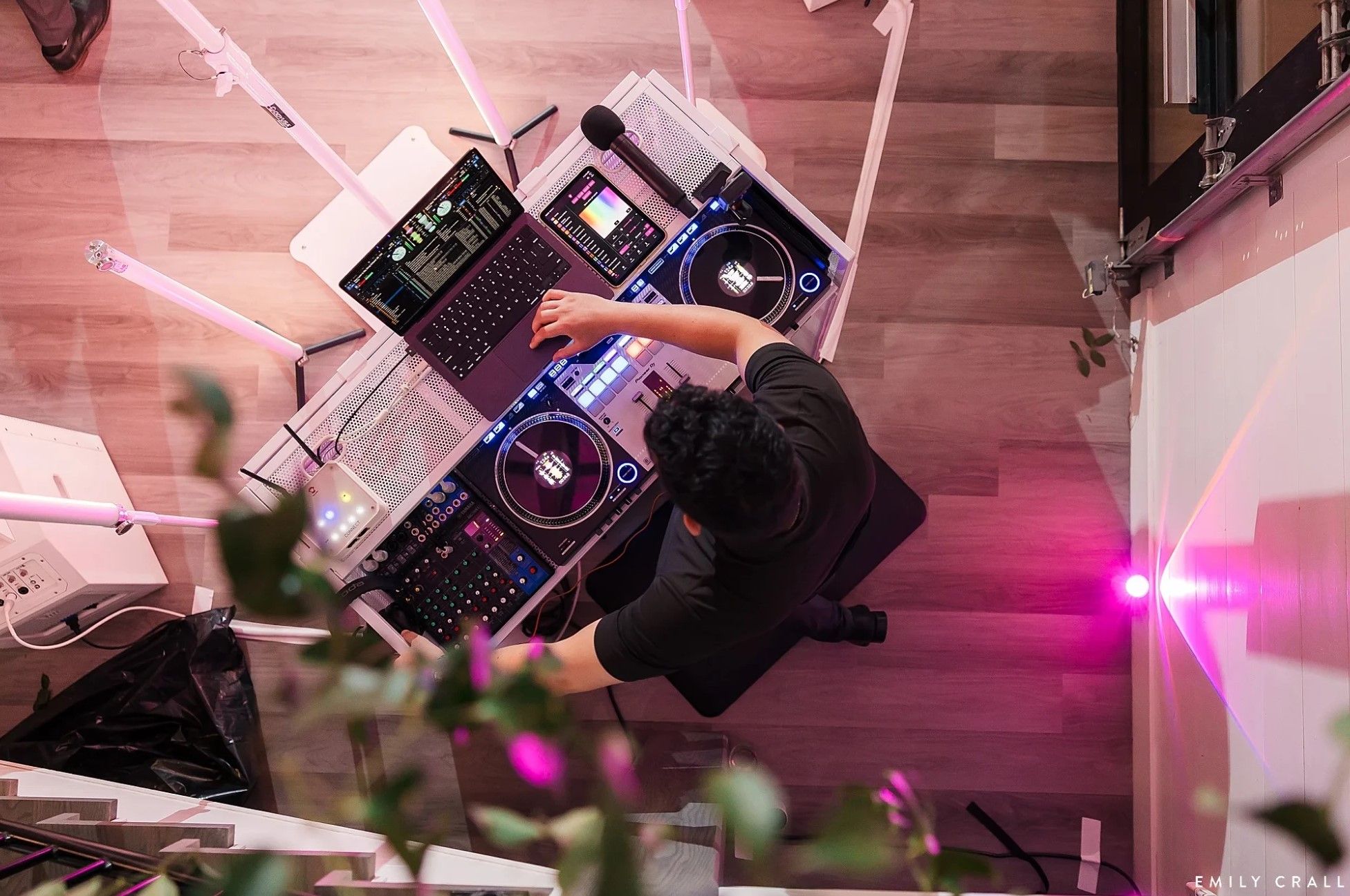 Overhead view of Davin at the decks, pink light washing the dance floor