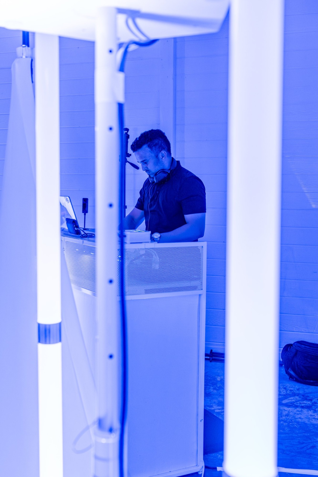 Davin Titus at his white booth, lit blue between tube lights