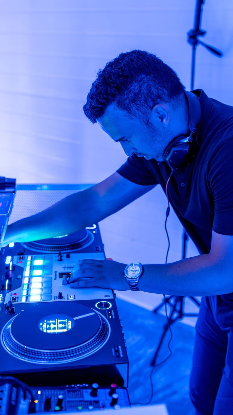 Davin mixing in blue light with headphones around his neck
